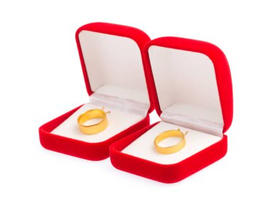 Kırmızı kadife kutudaki altın halkalar beyaz arkaplanda izole edilmiş.