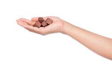 El ele tutuşan çikolatalı mantarlar beyaz arka planda izole edilmiş.