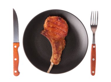 Izgara domuz kaburgası. Çatal ve bıçakla birlikte beyaz arka planda.