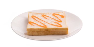 Beyaz arka planda portakal reçelli bir tabak ekmek.