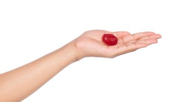 El ele tutuşan kiraz, beyaz bir arka planda izole edilmiş.