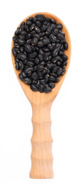 Tahta kepçedeki siyah fasulye beyaz arka planda izole edilmiş.