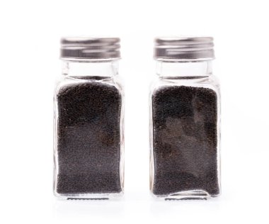 Beyaz arka planda izole edilmiş cam kabın içindeki limon fesleğeni tohumları