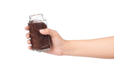 Beyaz arka planda el ele tutuşan kahve tozu şişesi.