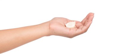 Beyaz arka planda sarımsak tutan el.