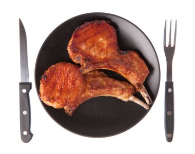 Izgara domuz kaburgası. Çatal ve bıçakla birlikte beyaz arka planda.