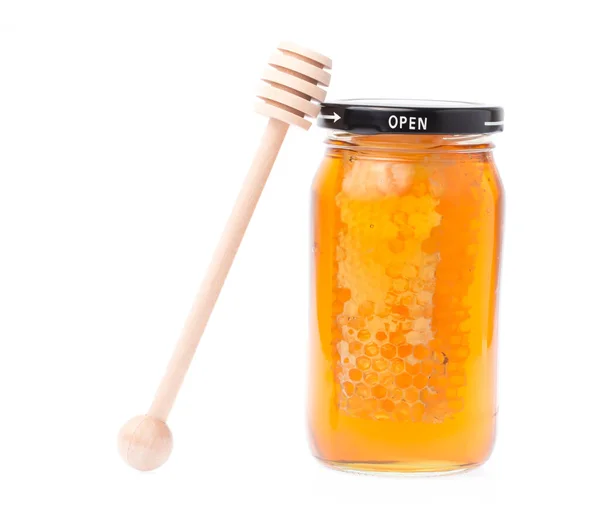 白い背景に蜂蜜と木の棒でいっぱいのガラス瓶 — ストック写真