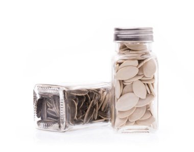 Beyaz arka planda izole edilmiş balkabağı çekirdekleri ve güneş tohumu.