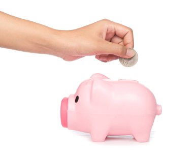 Beyaz arka planda izole edilmiş bir kumbara içine bozuk para sokmak.