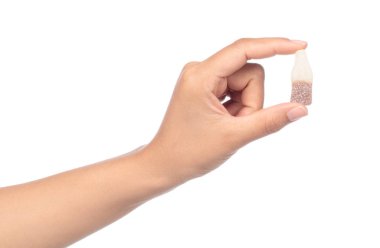 El ele tutuşan jöleli şekerler beyaz bir arka planda izole edilmiş.