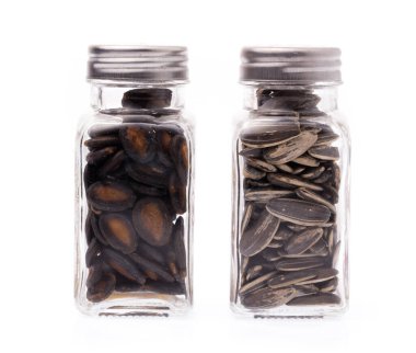 Beyaz arka planda izole edilmiş karpuz çekirdekleri ve güneş çiçeği tohumları.