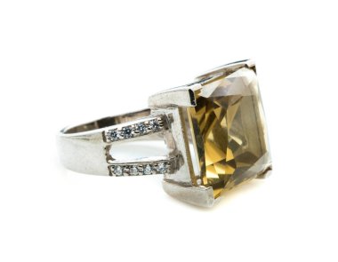 Beyaz zemin üzerinde sarı topaz taşı olan klasik bir yüzük.