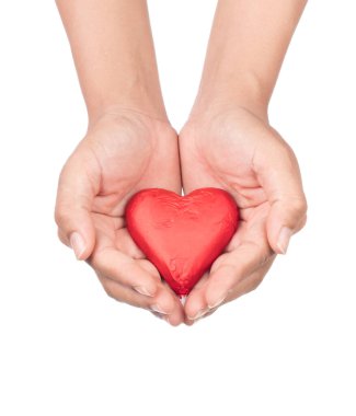 Beyaz arka planda izole edilmiş kırmızı folyoya sarılı çikolata kalp şeklinde el ele tutuşmalar.