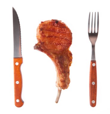 Beyaz arka planda ızgara domuz kaburgası ve çatal ve bıçak.