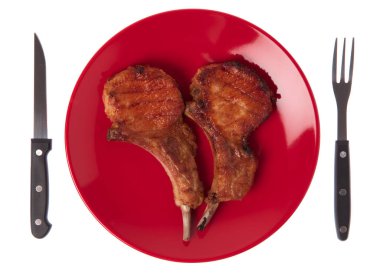 Izgara domuz kaburgası. Çatal ve bıçakla birlikte beyaz arka planda.