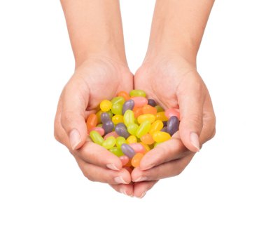 El ele tutuşan jöleli şekerler beyaz arka planda izole edilmiş.