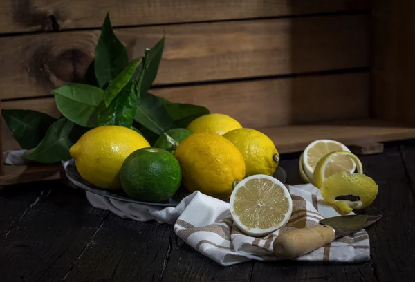Fresh ripe citrus. Lemons, limes on dark background — Stock Photo, Image