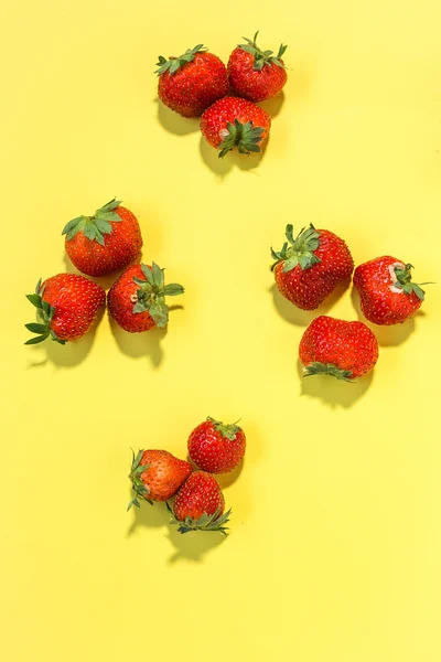 Rote Erdbeeren auf gelbem Tisch — Stockfoto