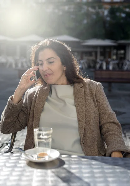 Genç, güzel, gülümseyen kadın cep telefonuyla konuşuyor. 