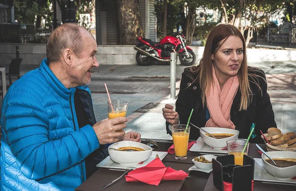 Seniorenpaar und ihre erwachsene Tochter reden und lachen — Stockfoto