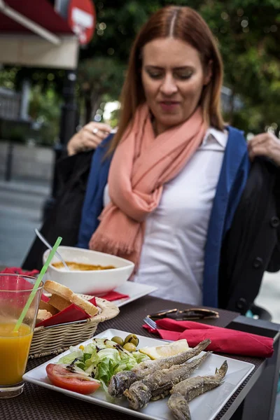 Blonde jonge vrouw eten buiten in de straat — Stockfoto