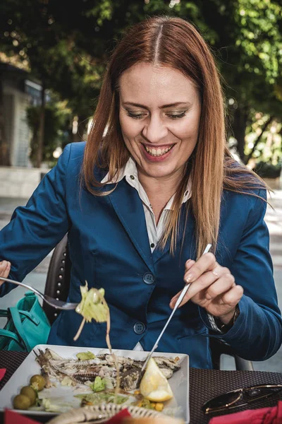 Wanita muda berambut pirang makan di luar ruangan di jalan — Stok Foto