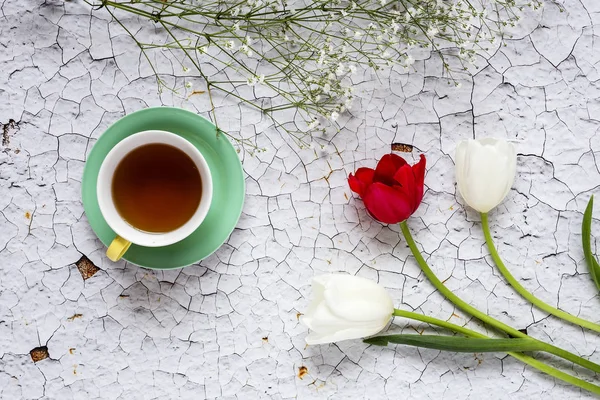 Taza de té con fondo floral con tulipanes rojos y blancos y — Foto de Stock