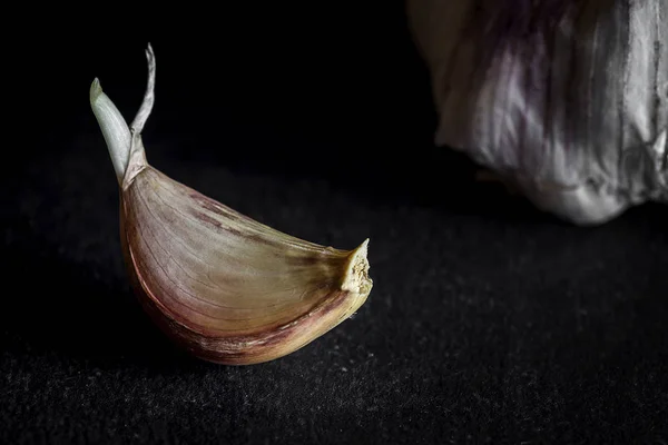Fresh garlic on old black wood table — Stock Photo, Image