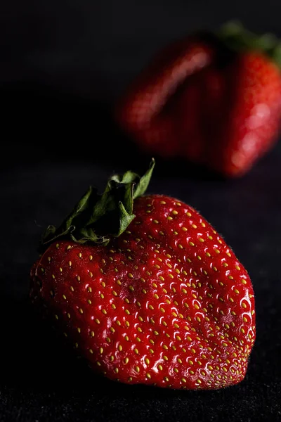 Verse aardbeien op oude zwarte houten tafel — Stockfoto