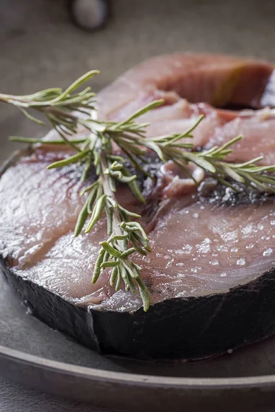 Raw tuna steak on plate and wooden table