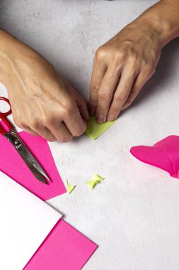 Kadın elleri kağıttan hayvan yapıyor.