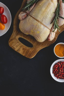 Tam pişmemiş tavuk, bitkiler ve baharatlarla.