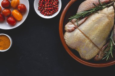 Tam pişmemiş tavuk, bitkiler ve baharatlarla.