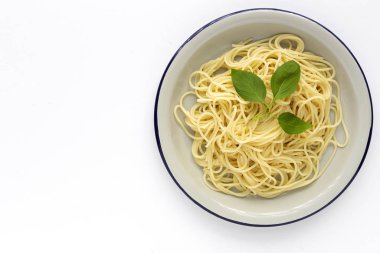 Domates ve fesleğen soslu ev yapımı spagetti, yukarıdan beyaz arka planda görünüyor. İtalyan pastası. Düz yatıyordu..