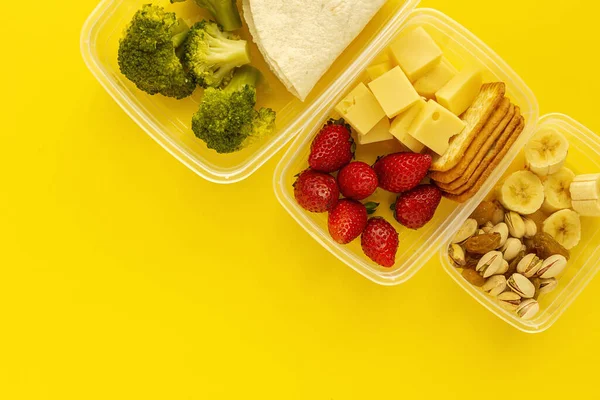 Food in Plastic containers ready to eat from above To take away. On yellow background. Healthy food. Vegan food. Flat lay