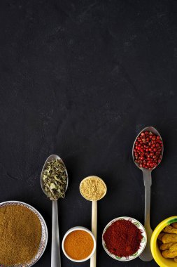 Yukarıdan bakıldığında, çeşitli türler ve şifalı bitkiler ve kaşıklar koyu arka planda. Düz yatıyordu. Üst görünüm