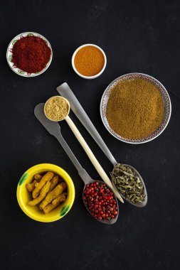 Yukarıdan bakıldığında, çeşitli türler ve şifalı bitkiler ve kaşıklar koyu arka planda. Düz yatıyordu. Üst görünüm