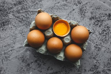 Gri arka planda iki renk tavuk yumurtası. Düz kat. Üst manzara.