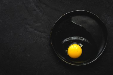 Yukardan koyu arkaplanda iki renk tavuk yumurtası. Düz katlı.
