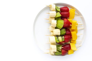 Muz, portakal, çilek, kivi ve mangolu sağlıklı meyve şişleri. Düz yatıyordu. Vejetaryen yemeği