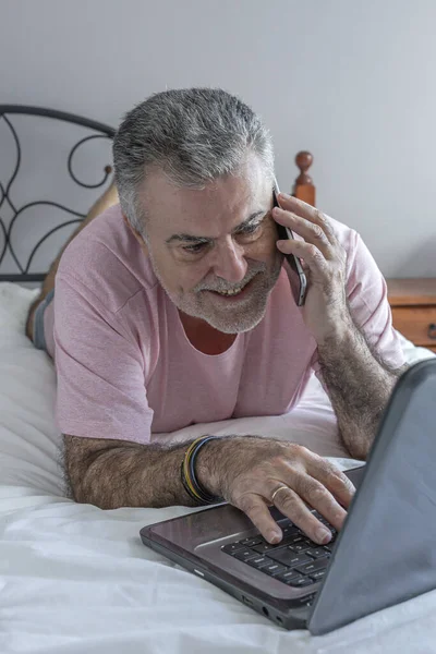 Homem Maduro Com Barba Trabalhando Cama Com Pijama Laptop Telefone — Fotografia de Stock