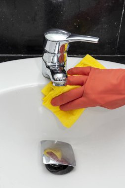 Koruyucu eldivenli, evi temizleyen ve dezenfekte eden tanınmamış bir kadının elleri. Coronavirus konsepti