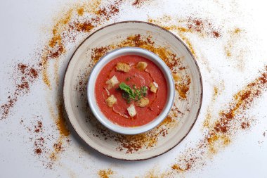 Beyaz arka planda ekmek, nane ve zeytinyağlı ev yapımı domates çorbası. Vejetaryen gıda kavramı.