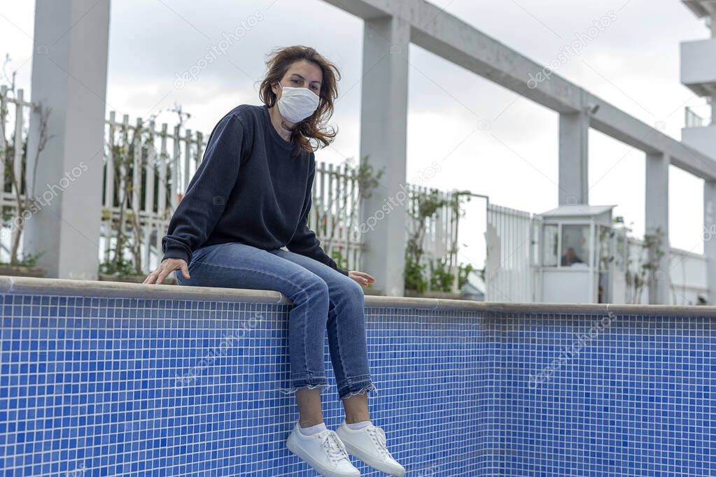 Mature woman with protective mask against coronavirus during quarantine in an private estate. Covid-19 concept