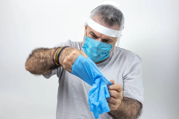 COVID-19. Adult man with double mask and latex gloves to protect himself from coronavirus on white background. Isolated