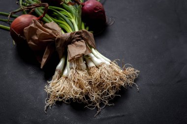 Koyu arkaplanda taze kırmızı ve beyaz soğan. Vejetaryen yemeği. Yiyecek.