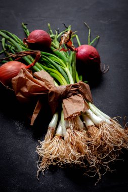 Koyu arkaplanda taze kırmızı ve beyaz soğan. Vejetaryen yemeği. Yiyecek.