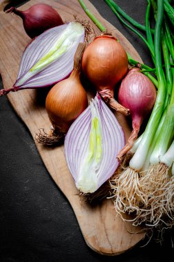 Koyu arkaplanda taze kırmızı ve beyaz soğan. Vejetaryen yemeği. Yiyecek.