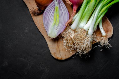 Koyu arkaplanda taze kırmızı ve beyaz soğan. Vejetaryen yemeği. Yiyecek.