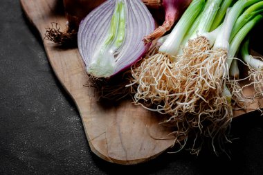 Koyu arkaplanda taze kırmızı ve beyaz soğan. Vejetaryen yemeği. Yiyecek.